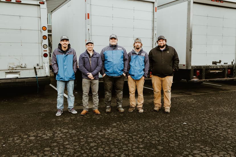 H2O Plumbing team members standing with service trucks