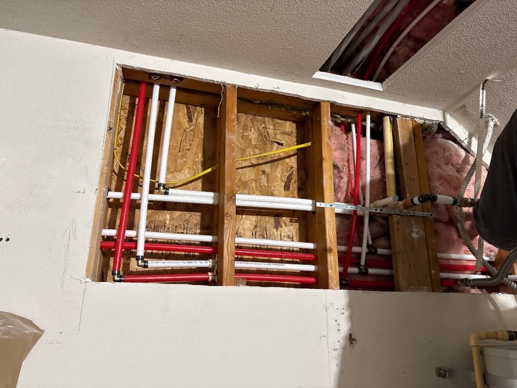 Wall section with multiple new repipe lines routed through framing in Vancouver home