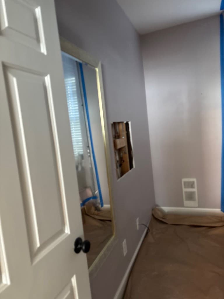 Room prepared with floor protection and wall access during residential repipe project