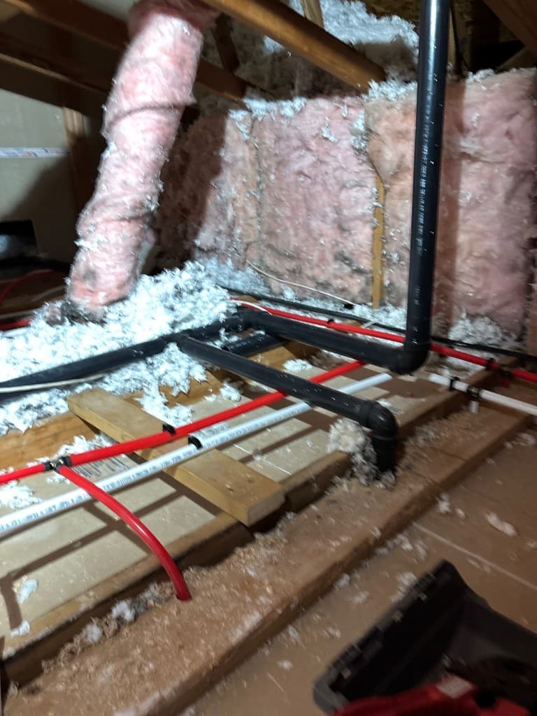 Attic-level line routing and drain work during residential repipe project