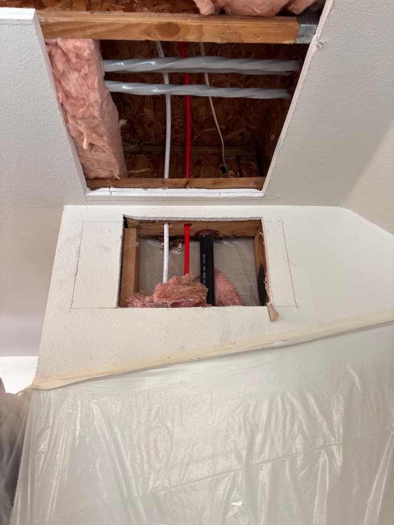Ceiling and wall openings showing new routing during residential repipe work