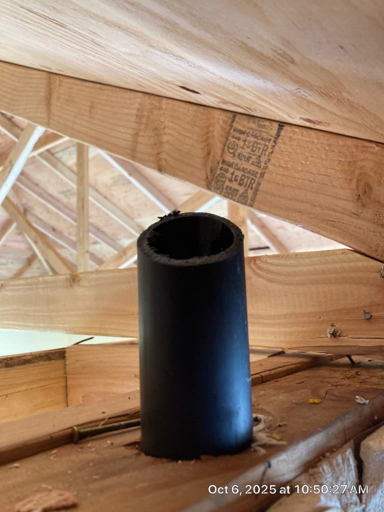 Close-up of vent stack penetration and tie-in point during post-fire restoration plumbing work