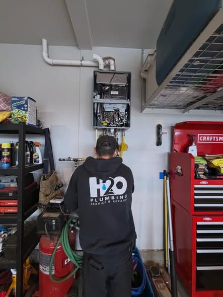H2O Plumbing technician servicing a tankless water heater in Clark County